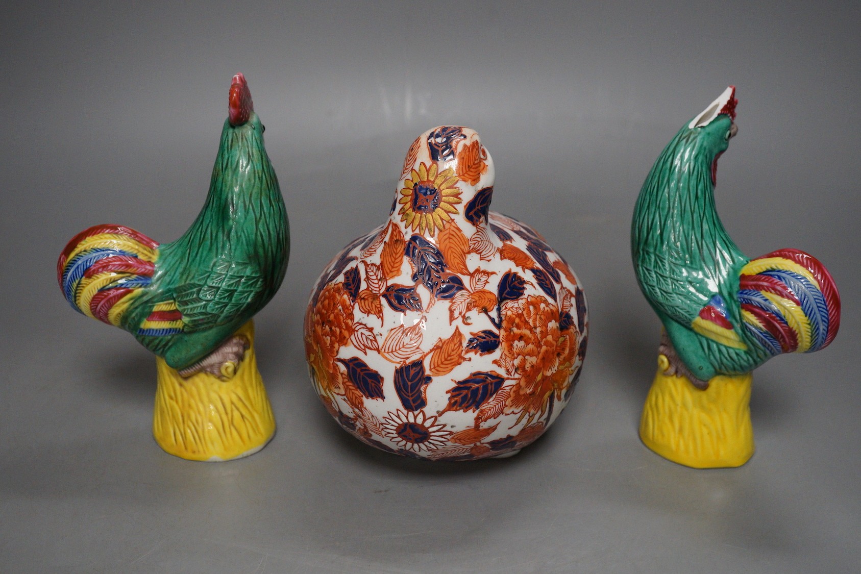 A pair of Chinese pottery roosters and an Imari quail, tallest 15cm